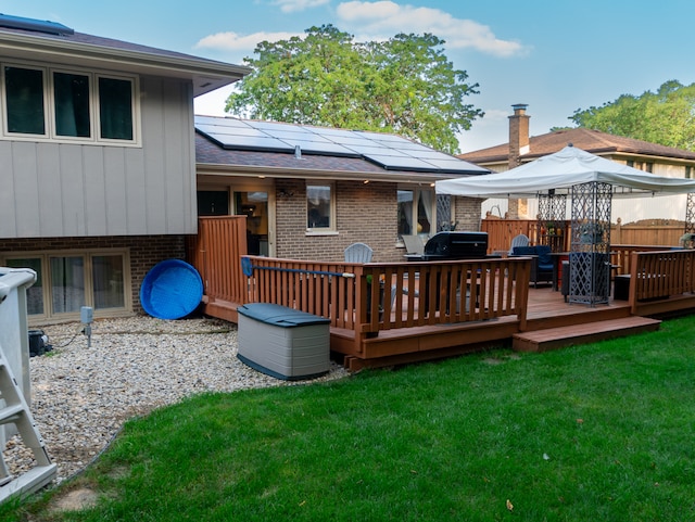 wooden terrace featuring a gazebo and a yard