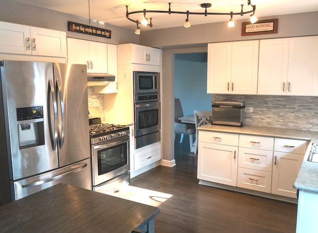 kitchen featuring hanging light fixtures, stainless steel appliances, dark hardwood / wood-style flooring, decorative backsplash, and white cabinets