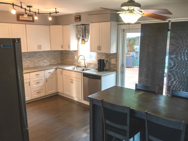 kitchen featuring sink, black fridge, dark hardwood / wood-style flooring, stainless steel dishwasher, and white cabinets