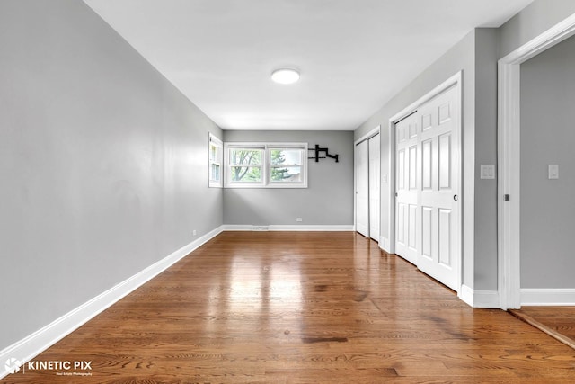 9036 Walnut Ave, Franklin Park, IL 60131 - unfurnished bedroom with two closets, wood finished floors, and baseboards