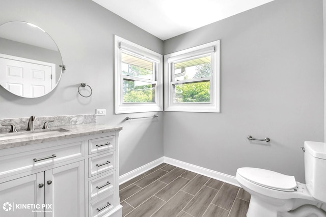 9036 Walnut Ave, Franklin Park, IL 60131 - bathroom with baseboards, toilet, vanity, and wood tiled floors