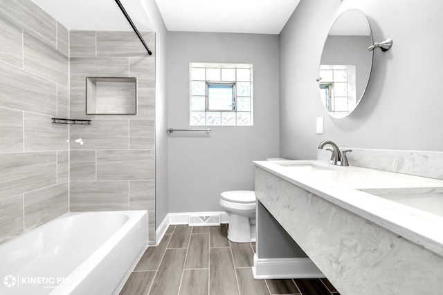 9036 Walnut Ave, Franklin Park, IL 60131 - bathroom featuring baseboards, toilet, double vanity, washtub / shower combination, and wood tiled floors