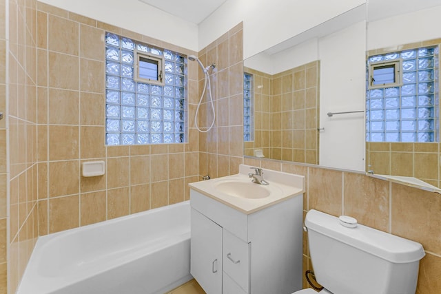 bathroom featuring  shower combination, tile walls, toilet, and vanity