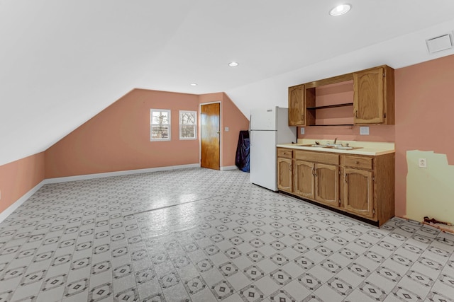 kitchen featuring lofted ceiling, a sink, light countertops, freestanding refrigerator, and open shelves