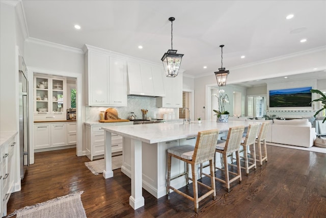 kitchen featuring a large island, white cabinetry, dark hardwood / wood-style flooring, and decorative light fixtures