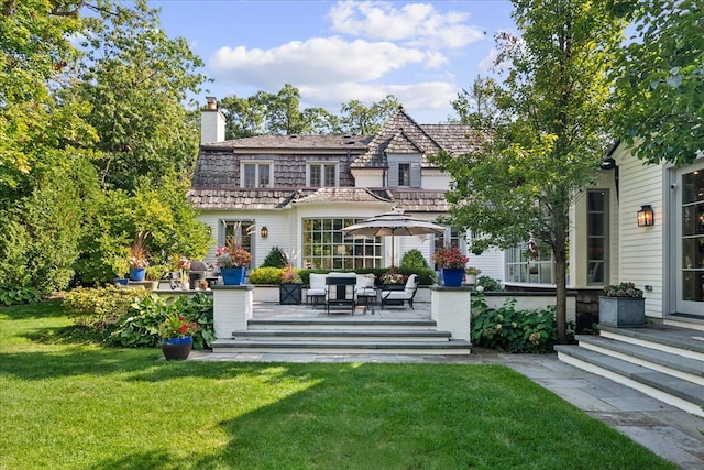 rear view of property featuring a lawn