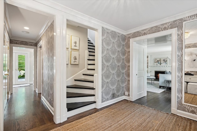 interior space with crown molding, hardwood / wood-style flooring, and a large fireplace