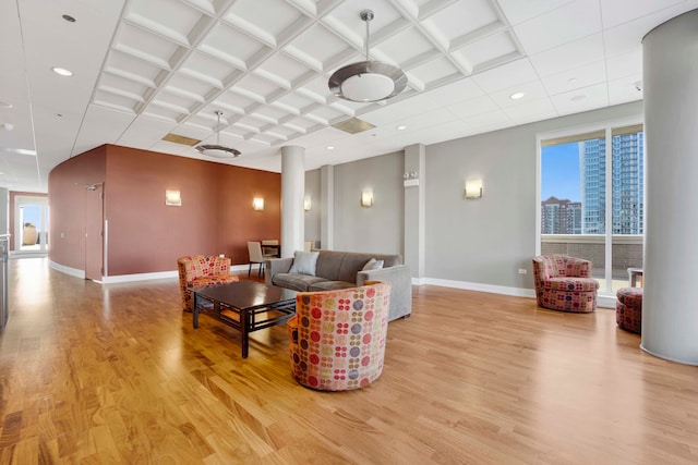 living room featuring coffered ceiling and light hardwood / wood-style flooring