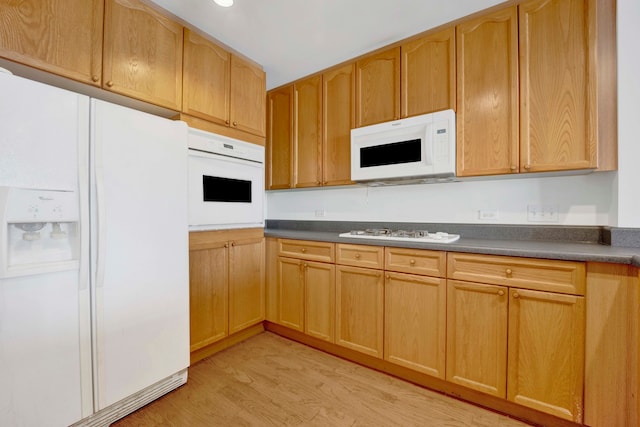 kitchen with white appliances and light hardwood / wood-style floors