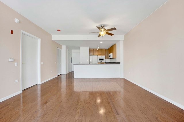 unfurnished living room featuring light hardwood / wood-style floors and ceiling fan