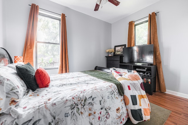 bedroom with multiple windows, hardwood / wood-style floors, and ceiling fan