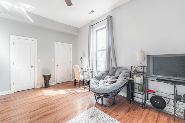 living area featuring ceiling fan and hardwood / wood-style floors