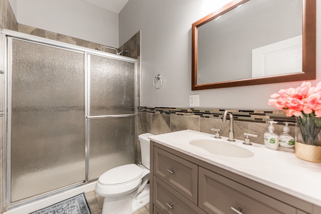 bathroom with vanity, toilet, an enclosed shower, tile walls, and tile patterned flooring