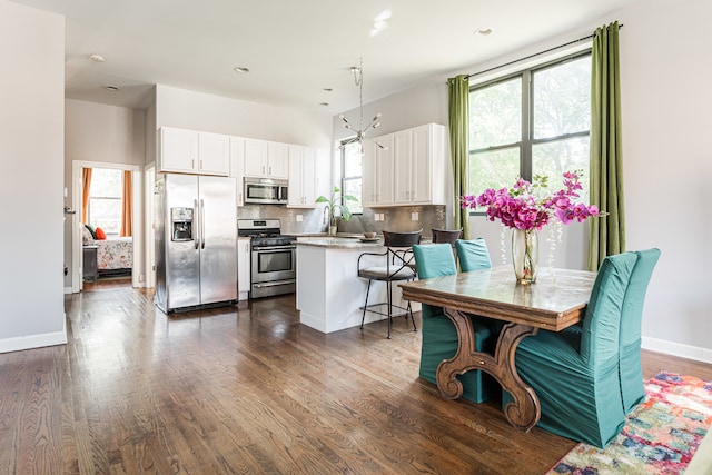 kitchen featuring appliances with stainless steel finishes, white cabinetry, and a wealth of natural light