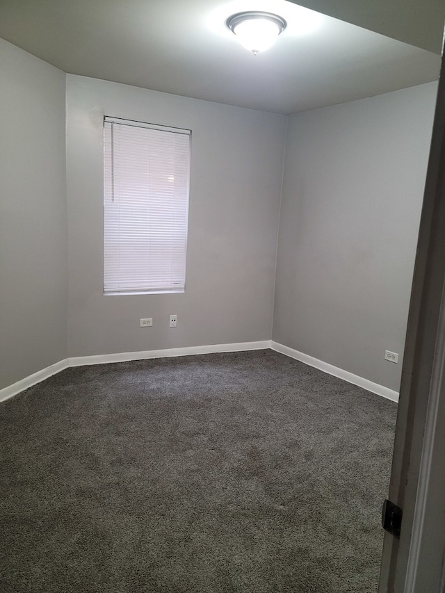 unfurnished room featuring dark colored carpet