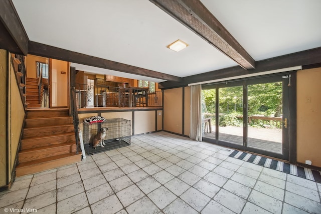 unfurnished living room with beam ceiling