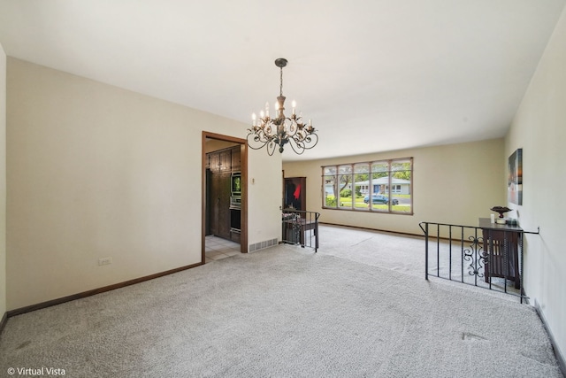 unfurnished room with light carpet and a notable chandelier