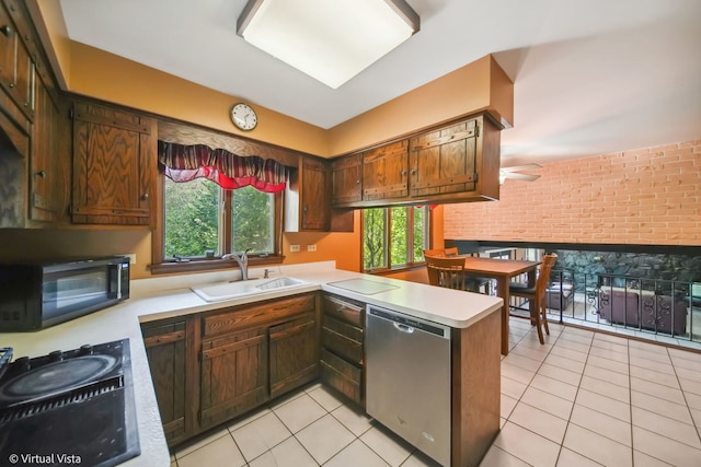 kitchen featuring light tile patterned flooring, brick wall, kitchen peninsula, dishwasher, and sink