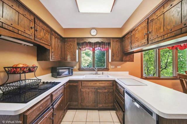 kitchen featuring black appliances, kitchen peninsula, sink, and light tile patterned floors