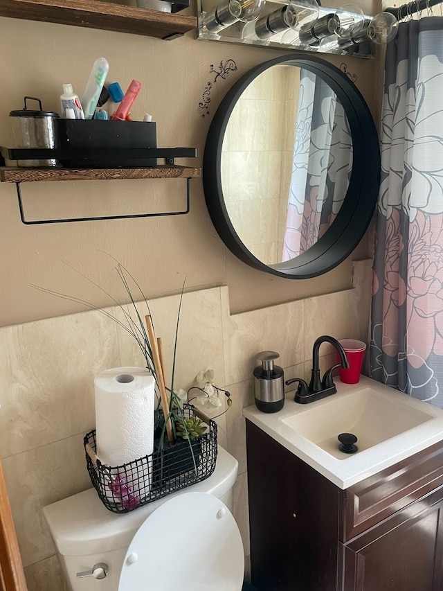 bathroom featuring vanity, toilet, and tasteful backsplash