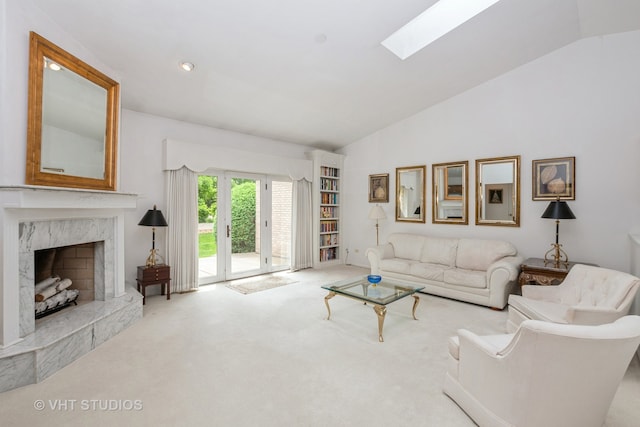 carpeted living room featuring a skylight, a premium fireplace, and high vaulted ceiling