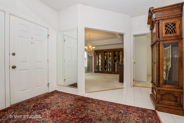 entrance foyer with an inviting chandelier and light colored carpet