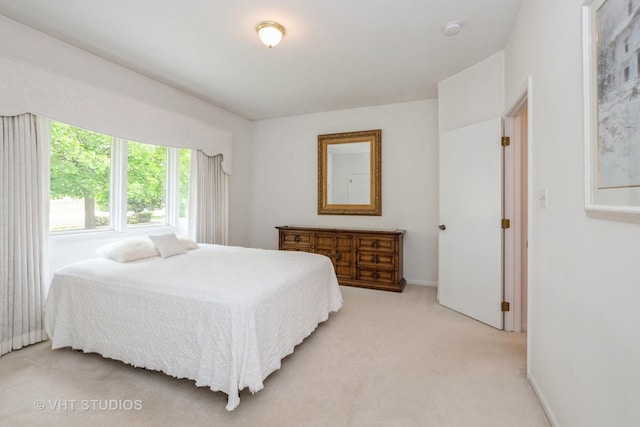 bedroom with baseboards and light carpet
