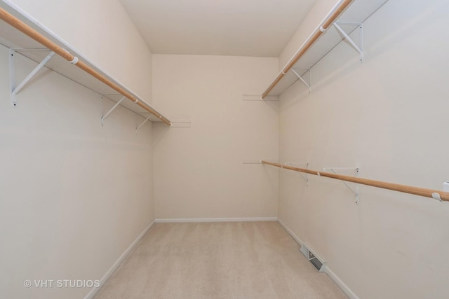 walk in closet featuring visible vents and light carpet