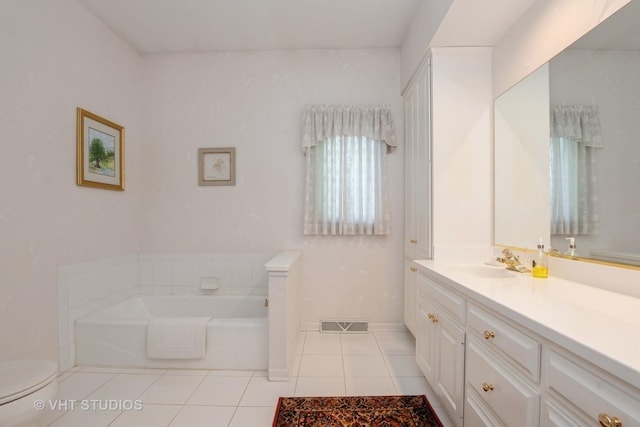 bathroom with visible vents, toilet, vanity, a garden tub, and tile patterned flooring