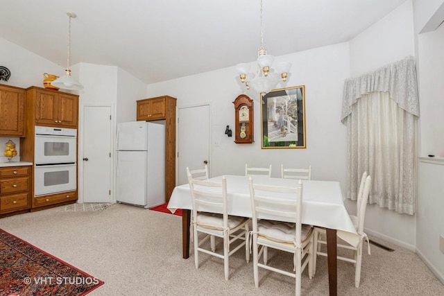 dining area featuring light colored carpet, visible vents, baseboards, and a chandelier