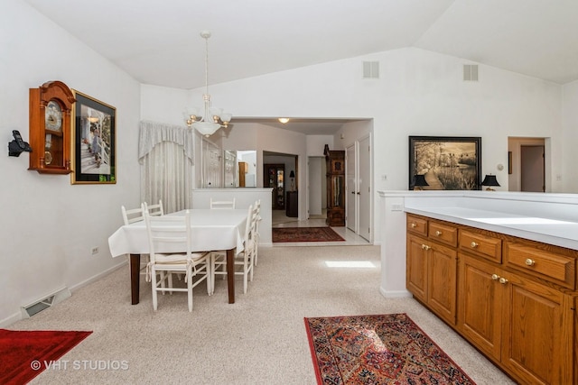 dining room with light colored carpet, lofted ceiling, visible vents, and a chandelier