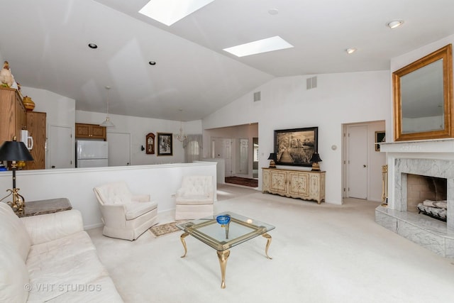 living area with a high end fireplace, lofted ceiling with skylight, light carpet, and visible vents