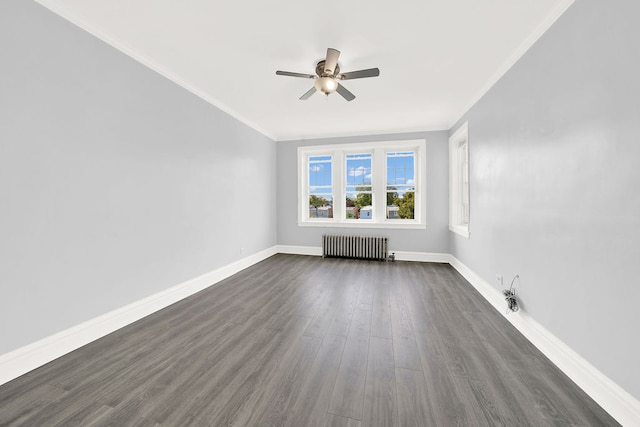 spare room featuring radiator, ceiling fan, crown molding, and dark hardwood / wood-style flooring