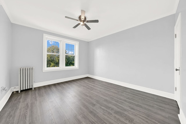 spare room with ceiling fan, dark wood-type flooring, and radiator heating unit