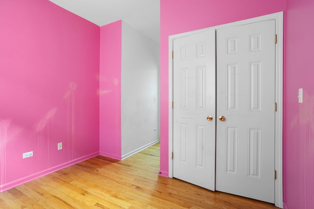 unfurnished bedroom with a closet and hardwood / wood-style flooring