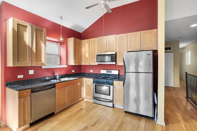 kitchen with pendant lighting, light hardwood / wood-style floors, high vaulted ceiling, appliances with stainless steel finishes, and ceiling fan