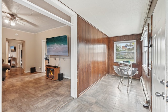 sunroom with ceiling fan and baseboard heating