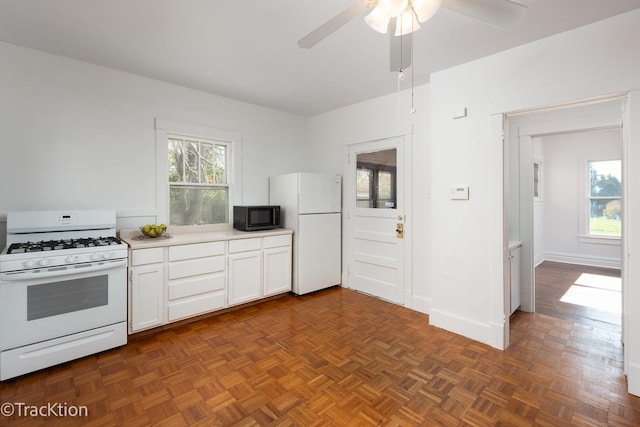 kitchen featuring white cabinets, ceiling fan, dark parquet flooring, and white appliances