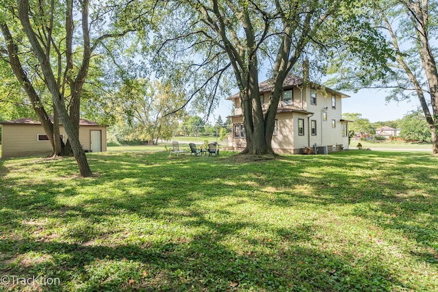 view of yard with central AC and an outdoor structure