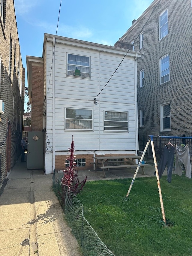 back of property with a yard and a patio area