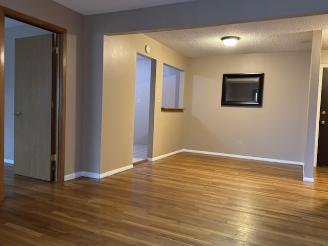 unfurnished room featuring hardwood / wood-style floors and a textured ceiling