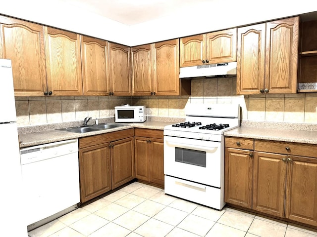 kitchen with backsplash, sink, light tile patterned floors, and white appliances