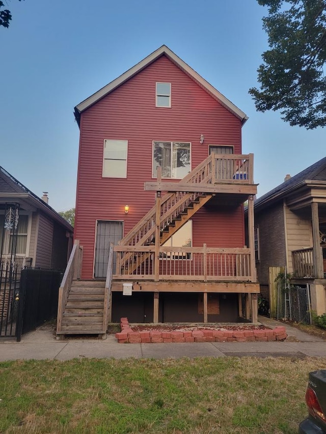 back of property featuring a wooden deck and a yard