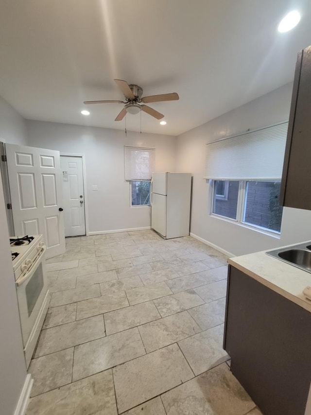 kitchen with white appliances, sink, and ceiling fan