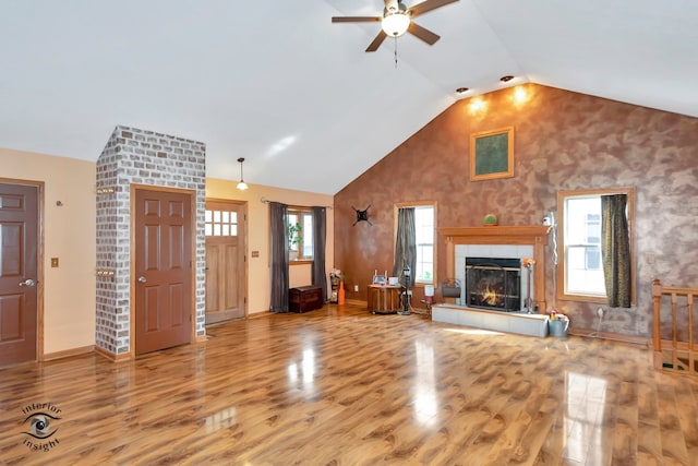 unfurnished living room with a wealth of natural light, wood-type flooring, and a fireplace