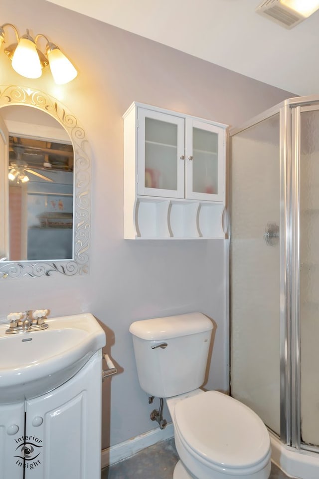 bathroom with vanity, a shower with shower door, and toilet