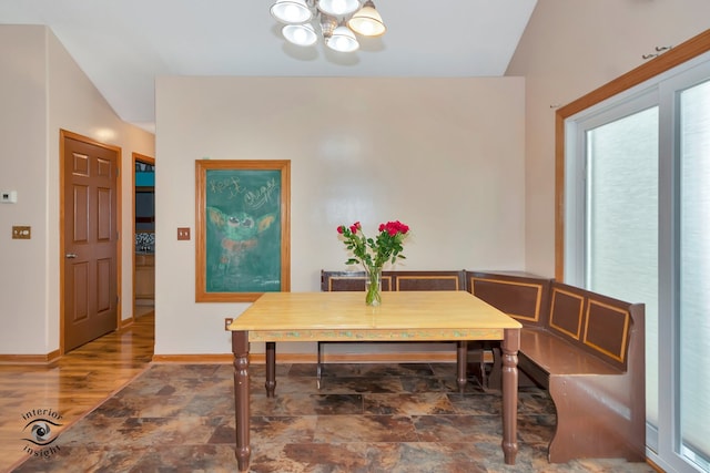 dining area featuring a notable chandelier, vaulted ceiling, and dark wood-type flooring