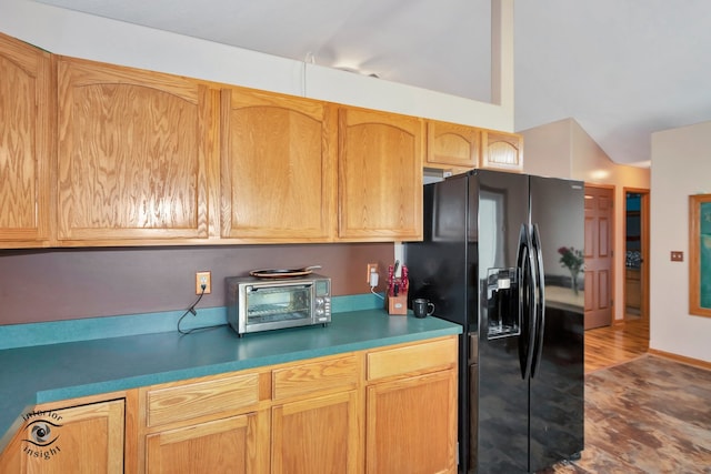 kitchen featuring hardwood / wood-style flooring and black fridge with ice dispenser