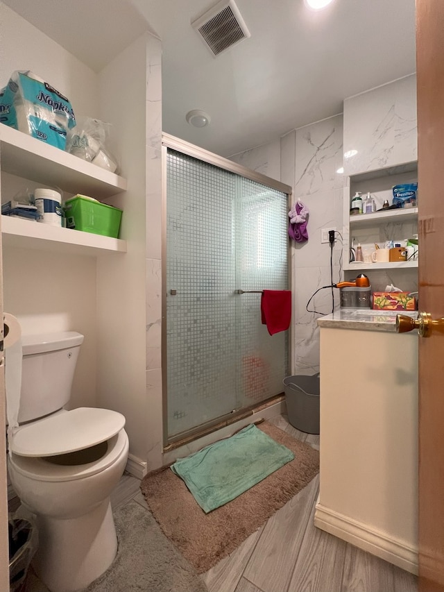 bathroom featuring walk in shower, wood-type flooring, and toilet