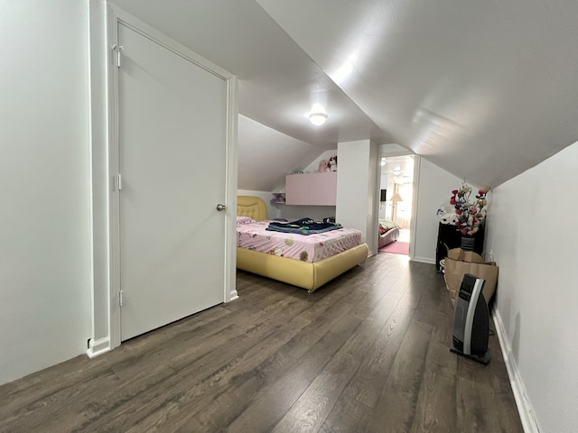 bedroom with wood-type flooring and vaulted ceiling